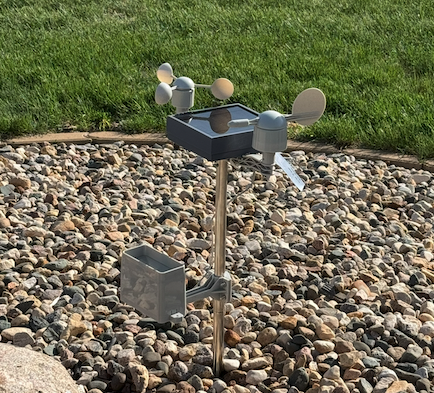 Assembled weather station mounted outdoors with solar panel.